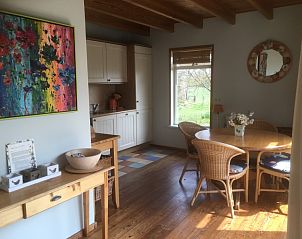 Essbereich in der Texel Villa Duinzicht, De Koog, Texel mit farbenfroher Malerei und Gartenblick.