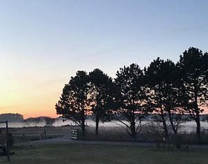 Atemberaubender Sonnenuntergang in der Texel Villa Duinzicht, De Koog, Texel mit Silhouetten von Bumen.