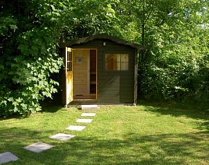 Charmant tuinhuisje bij Park Verste Coogh vakantiehuis in De Koog, Texel omgeven door weelderig groen.
