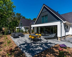 Electric charging station at cottage in Den Burg, Texel, among green surroundings.
