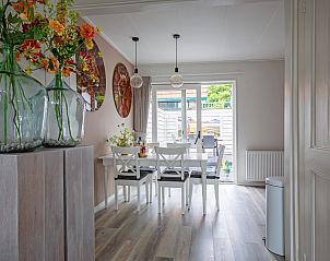 Esszimmer des Ferienhauses Schoonoord in Den Burg, Texel, mit elegantem Tisch und bunten Blumen.