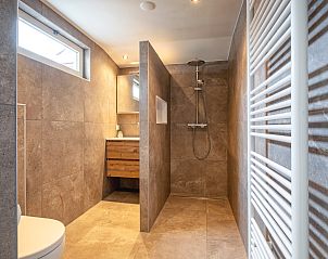 Luxurises Badezimmer des Ferienhauses Schoonoord in Den Burg, Texel, mit begehbarer Dusche und moderner Ausstattung.