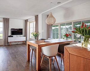 Spacious dining room in Waddenduyn vacation home, Den Burg, Texel with flowers on the table.