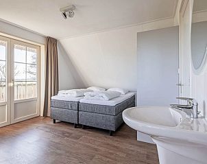 Bedroom in Waddenduyn vacation home, Den Burg, Texel with double bed and balcony.