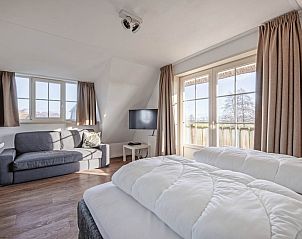 Comfortable bedroom in Waddenduyn vacation home, Den Burg, Texel with extra seating area.