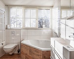 Luxury bathroom in Waddenduyn vacation home, Den Burg, Texel with bathtub and large window.