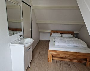 Attraktives Schlafzimmer im Ferienhaus Kogerstraat, Den Burg, Texel. Gerumiges Doppelbett unter einer Dachschrge fr Ruhe und Komfort.
