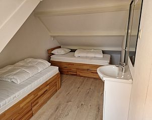 Gemtliches Schlafzimmer mit zwei Einzelbetten im Ferienhaus Kogerstraat, Den Burg, Texel. Perfekt fr einen Familienaufenthalt.