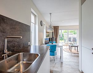 Open kitchen and dining area in Cottage in Den Burg, Texel, vacation home with garden view.