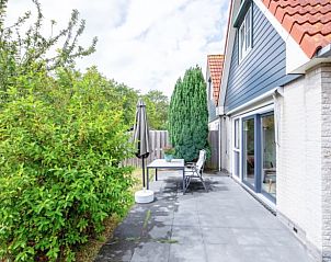 Sunny terrace at Cottage in Den Burg, Texel, vacation home with green garden.