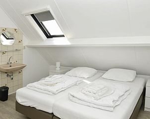 Lichte slaapkamer met dakraam in Huisje in Den Burg, Texel, vakantieaccommodatie met comfortabele bedden.