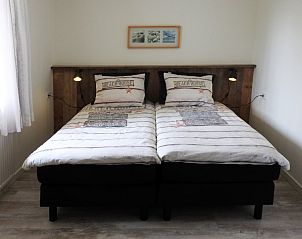 Ruime slaapkamer met tweepersoonsbed in familie Smit vakantiehuis Den Burg Texel.