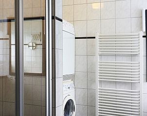 Praktische wasruimte in familie Smit vakantiehuis Den Burg Texel met wasmachine en droger.