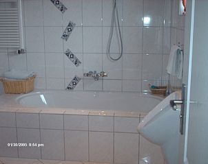 Ruime badkamer in BB Plaatsman, Den Burg, Texel met elegant bad en moderne voorzieningen voor ultiem comfort.