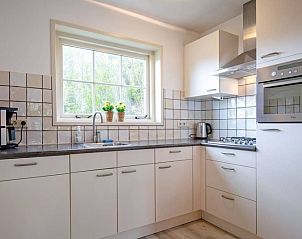 Fully equipped kitchen in Holiday home 5 Persoons Den Burg Texel overlooking the garden.