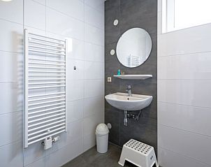 Stijlvolle badkamer met wastafel en spiegel in Vakantiehuisje in Den Burg, Texel.