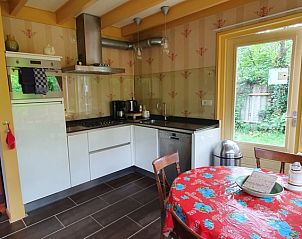 Cozy kitchen of The Achterhuys vacation home in Den Burg, Texel with dining area.