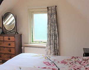 Bedroom with antique chest of drawers in Het Achterhuys vacation home on Texel.