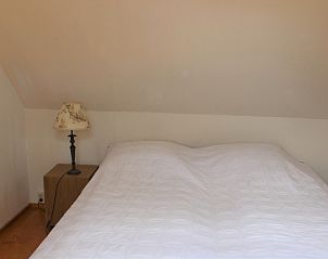 Cozy bedroom with bedside table in Het Achterhuys vacation home on Texel.