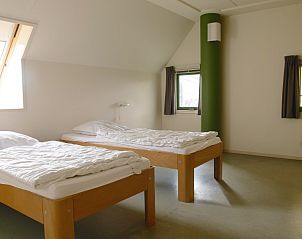 Ruime slaapkamer in Vakantiewoning - Molenhuizen, Den Burg, Texel met twee eenpersoonsbedden en uitzicht.