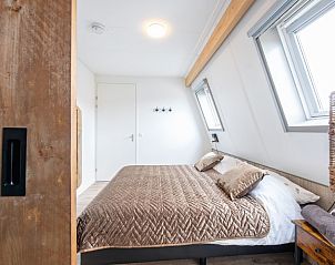 Knusse slaapkamer met houten accenten in Wulpenweid Bed en Parking, Texel.