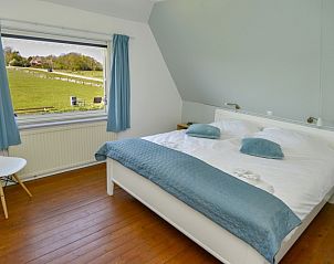 Schlafzimmer im Bungalow Het Lam, Texel mit Blick auf grne Felder in Den Burg, ideal fr einen entspannten Aufenthalt.