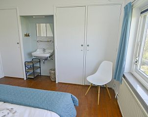 Helles Schlafzimmer mit Waschbecken im Bungalow Het Lam, Den Burg, Texel. Komfortables Ferienhaus auf den Watteninseln.