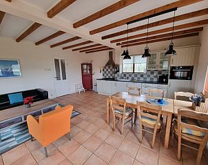 Gezellige eetruimte in Vakantiehuis Duinzicht Den Burg Texel met houten meubels en open keuken.