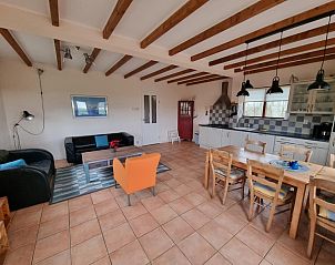 Woonkamer van Vakantiehuis Duinzicht Den Burg Texel met comfortabele zithoek en open keuken.