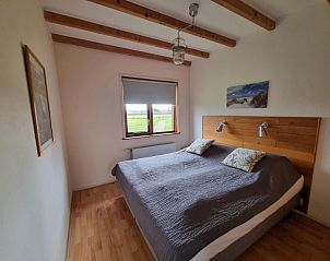 Slaapkamer in Vakantiehuis Duinzicht Den Burg Texel met tweepersoonsbed en uitzicht op weiland.