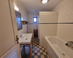 Moderne badkamer in Vakantiehuis Duinzicht Den Burg Texel met ligbad en stijlvolle tegels.