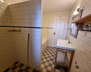 Stijlvolle badkamer in Vakantiehuis Duinzicht Den Burg Texel met douche en witte tegels.