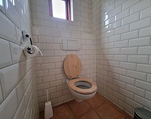 Netjes toilet in Vakantiehuis Duinzicht Den Burg Texel met wit betegelde muren.