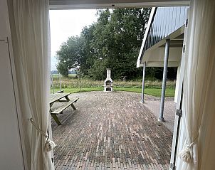 Terrace with barbecue in 44 - Aldubo Landhuis, Den Burg, Texel, surrounded by greenery.
