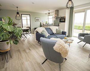 Ruime woonkamer van Onder de Wol vakantiehuis Texel met uitzicht op de natuur.