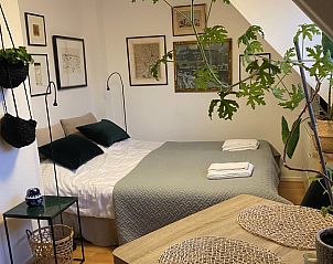 Gezellige slaapkamer in Tweepersoons studio 1 in Den Hoorn, Texel met kunst aan de muur en groene accenten.