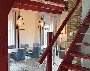 Open trap in 't Wambuis, Den Hoorn, Texel met zicht op de eetkamer en stijlvolle inrichting.