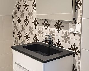 Stijlvolle badkamer in 't Wambuis, Den Hoorn, Texel met modern wastafelmeubel en decoratieve tegels.