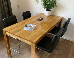 Gezellige eetruimte in vakantiehuis 4780 - Van der EL, Den Hoorn, Texel met houten tafel en planten.