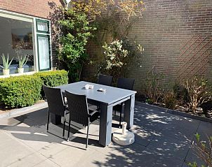 Zonnig terras van vakantiehuis 4780 - Van der EL in Den Hoorn, Texel met tuinmeubilair en groene planten.