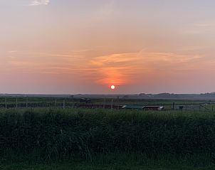 Adembenemende zonsondergang bij vakantiehuis 4780 - Van der EL in Den Hoorn, Texel met uitzicht over de velden.