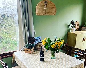 Eettafel met bloemen en wijn in Vakantiehuis Vogelsand Den Hoorn Texel, sfeervolle setting.