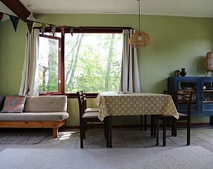 Lichte woonruimte in Vakantiehuis Vogelsand Den Hoorn Texel met grote ramen en comfortabele zitplek.