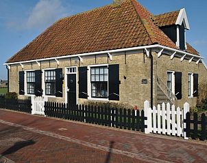 Charmant Vakantiehuisje in Den Hoorn Texel met authentieke gevel en rode dakpannen.