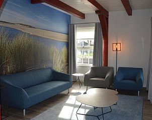 Gezellige woonkamer in Vakantiehuisje Den Hoorn Texel met strandthema en comfortabele zithoek.