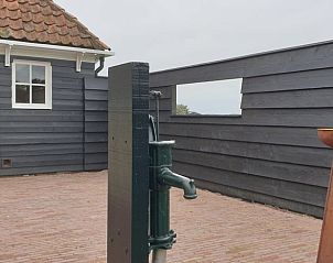 Rustiek terras bij Vakantiehuisje Den Hoorn Texel met authentieke waterpomp.
