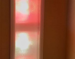 Unieke lichtinval in Vakantiehuisje Den Hoorn Texel met sfeervol gekleurd raam.