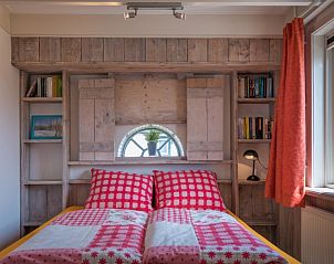 Sfeervolle slaapkamer in Appartement Heem, Den Hoorn, Texel, met gezellige bedden en een raam met uitzicht op de omgeving.