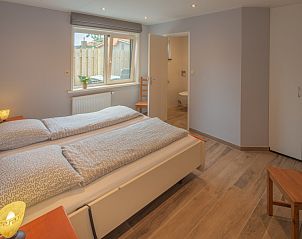 Sfeervolle slaapkamer in bungalow 3685, Oosterend Texel, met tweepersoonsbed en natuurlijke lichtinval.