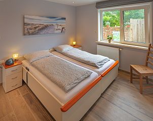 Lichte slaapkamer in bungalow 3685, Oosterend Texel, met uitzicht op de tuin en comfortabele bedden.